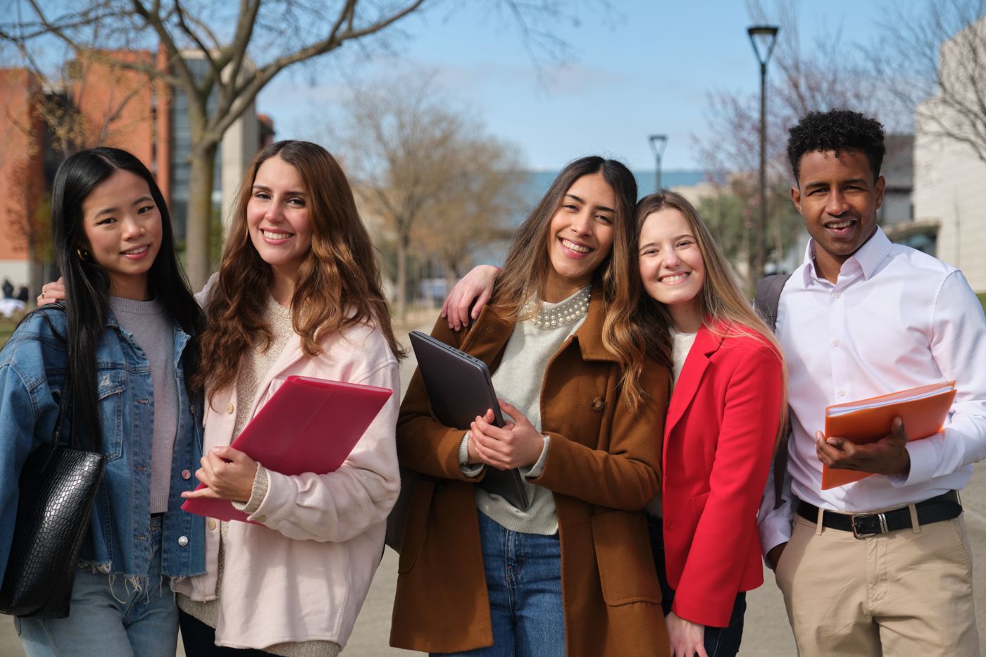 A group of smiling university students outdoors on campus