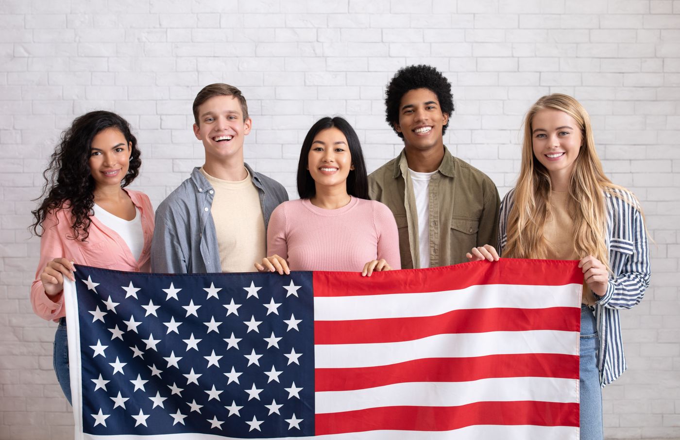 A group of international students holding a U.S. flag